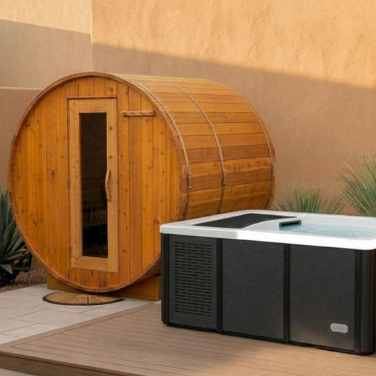 Wooden barrel sauna and hot tub on a patio with a beige wall background